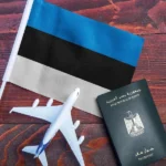 صورة لجواز سفر مصري بجانب علم إستونيا ونموذج طائرة صغير، كرمز لموضوع فيزا استونيا للمصريين.