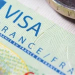ملصق تأشيرة شنغن فرنسا (VISA FRANCE EU SCHENGEN) يُظهر العملة الأوروبية في الخلفية.